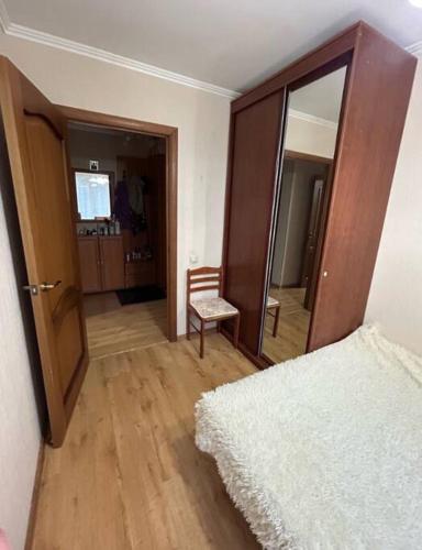 1 dormitorio con cama, silla y espejo en Weendrush Apartment 21, 