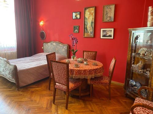 a dining room with a table and a red wall at Retro big Apartment with two balconies and lift in Karlovy Vary