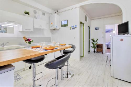 een keuken met een houten tafel en stoelen bij Tarbes Marcadieu T2 RDC et 1er étage Centre ville et nature in Tarbes