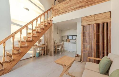 a living room with a staircase and a kitchen at Le Village Aewol F in Jeju
