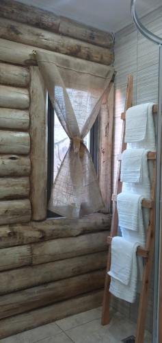 a window in a log cabin with a curtain at Ventanas al Norte in Chascomús