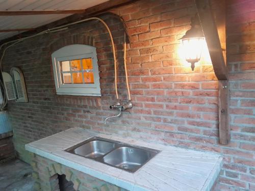 uma cozinha com um lavatório numa parede de tijolos em Achter de Vesting em Bourtange