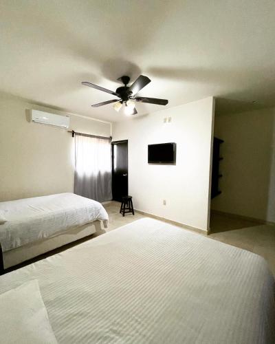 a bedroom with two beds and a ceiling fan at Galería Concordia in Antiguo Tamuín