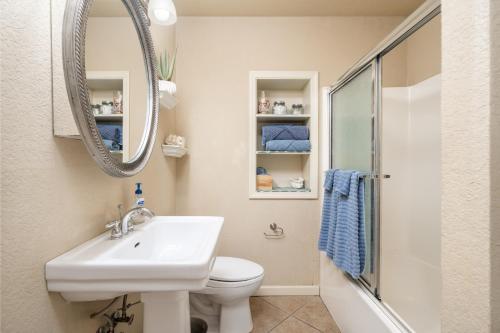 a bathroom with a sink and a toilet and a mirror at Ember’s View, Spa City Jewel- Lovely Lake Condo in Hot Springs