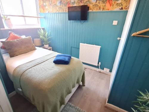 een slaapkamer met een bed met een blauwe muur bij Birdy Room - Lemur Lodge in Bournemouth