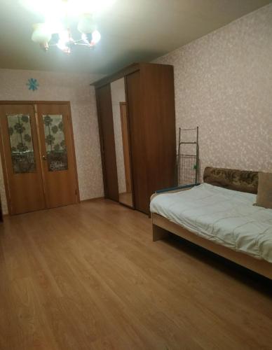 1 dormitorio con 1 cama y suelo de madera en Battenbot Apartment 9p8 