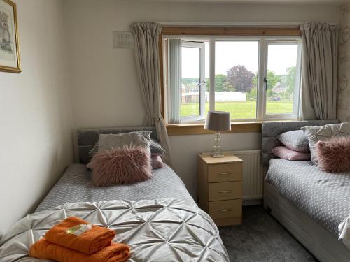 1 Schlafzimmer mit 2 Einzelbetten und einem Fenster in der Unterkunft 3bedroom 1bathroom 1 shower room in quiet area in Inverness