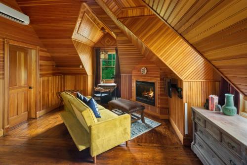 a living room with a yellow couch and a fireplace at Hotel Mountain Brook in Tannersville