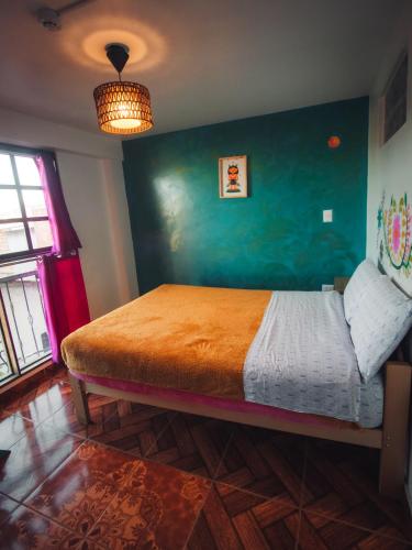 a bedroom with a bed with a green wall at The Chusay Rooftop in Cusco