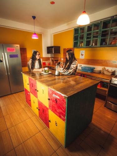 two women sitting at a kitchen island in a kitchen at The Chusay Rooftop in Cusco