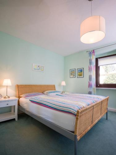 a bedroom with a large bed and a window at Ferienhaus an der Austwies in Nonnweiler
