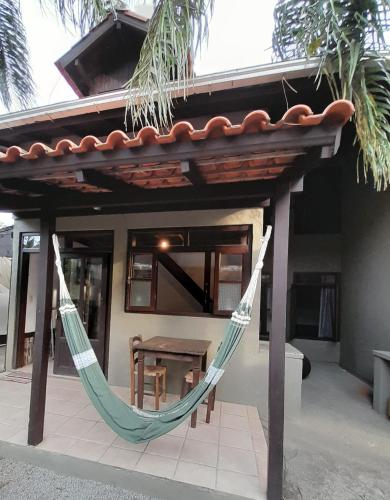 a hammock hanging from a porch of a house at Pousada das Palmeiras in Garopaba