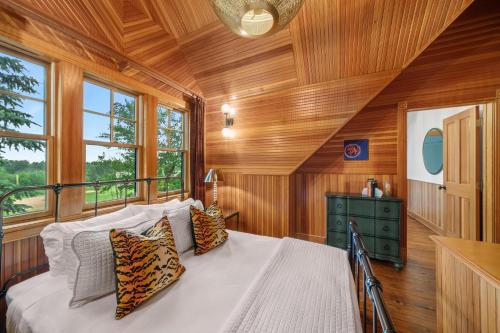 a bedroom with a bed in a room with wooden walls at Hotel Mountain Brook in Tannersville