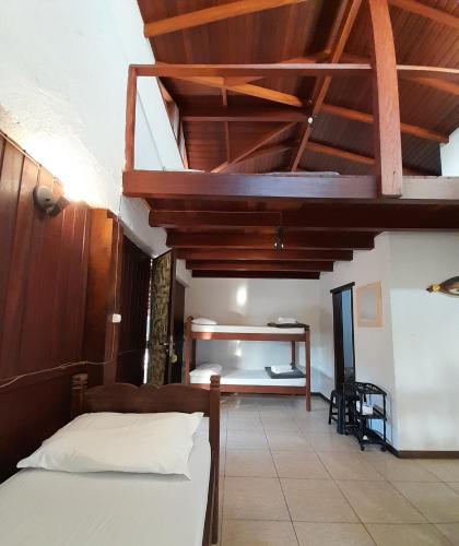 a bedroom with a bed and a wooden ceiling at Pousada das Palmeiras in Garopaba