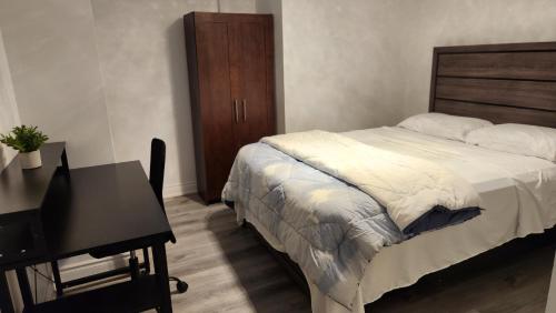 1 dormitorio con cama, mesa y escritorio en 2 Bedrooms 2 washrooms 2 parking spots Basement Apartment, en Newmarket