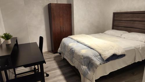 a bedroom with a bed and a table and a desk at 2 Bedrooms 2 washrooms 2 parking spots Basement Apartment in Newmarket