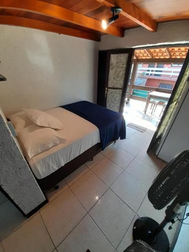 a bedroom with a bed in a room with a window at Pousada das Palmeiras in Garopaba