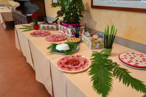 a long table with plates of food on it at Hotel Rifugio la Foresta in Vallombrosa