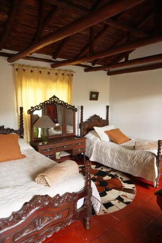 a bedroom with two beds and a table with a mirror at Posada el portal de la Loma in Pesca