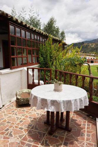 a table with a white table cloth on a balcony at Posada el portal de la Loma in Pesca