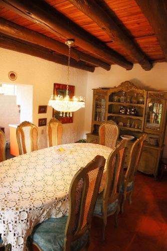 a dining room with a table with chairs and a chandelier at Posada el portal de la Loma in Pesca