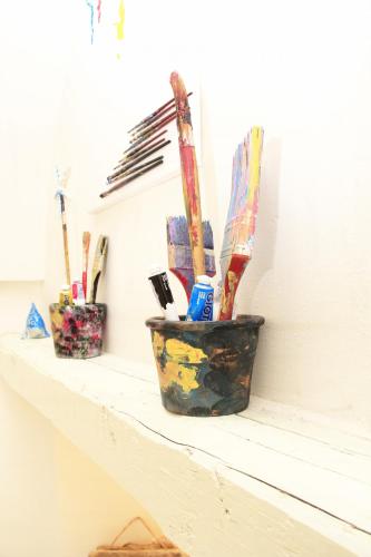 a shelf with a pot filled with tooth brushes at Karen House B&B in Polignano a Mare