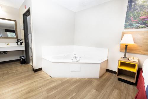 baño blanco con lavabo y cama en Days Inn by Wyndham Dayton Huber Heights Northeast, en Huber Heights