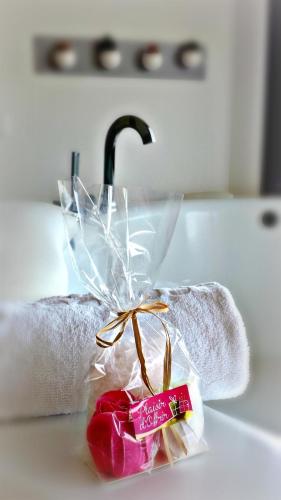 un article rose assis sur un comptoir à côté d'un évier dans l'établissement Les Suites du Saint Nazaire - Les Balcons de la Cité, à Carcassonne