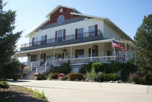 a white house with an american flag on it at Eagle’s Landing Lodge in Custer