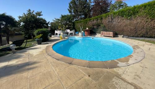 - une grande piscine dans une cour avec une terrasse dans l'établissement La Maison Sarthoise - 24H Du Mans - 4 pers, à Saint-Saturnin