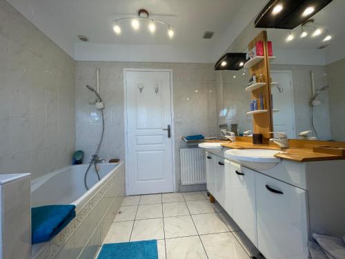 a bathroom with a tub and a sink and a bath tub at La Maison Sarthoise - 24H Du Mans - 4 pers in Saint-Saturnin