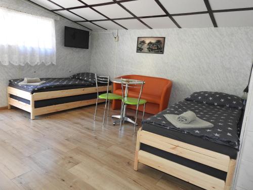 a room with three beds and a table and chairs at Ubytovanie u Krokodíla in Banská Belá