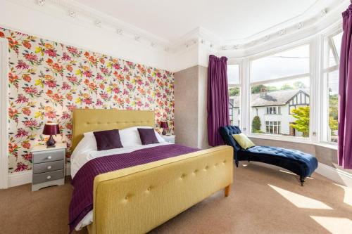 1 dormitorio con 1 cama, 1 silla y 1 ventana en The Tall House - Sleeps 16, en Keswick