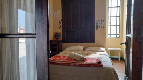 un dormitorio con una cama con un animal de peluche en República Hostel en San Pedro