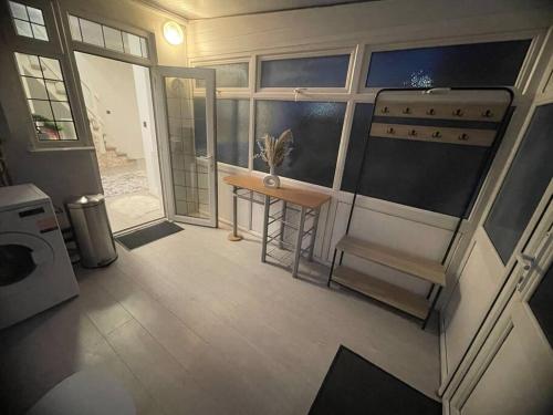 Elle offre une vue sur une chambre dotée d'une table et d'une fenêtre. dans l'établissement The Cozy Modern Eastlea Home, à Garston