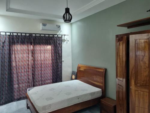 une petite chambre avec un lit et une fenêtre dans l'établissement Appartement entier proche de la plage Yoff BCEAO A2, à Dakar