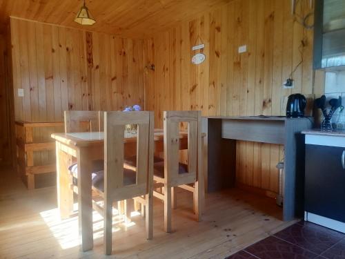 El Refugio de la Estancia في Isla Negra: مطبخ مع طاولة وكراسي في غرفة