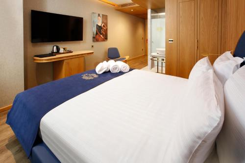 a bedroom with a large white bed with a flat screen tv at Kate Hotel Special Class & SPA in Istanbul