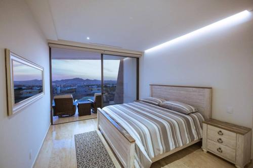 a bedroom with a large bed and a large window at Increíble departamento de lujo in El Pueblito