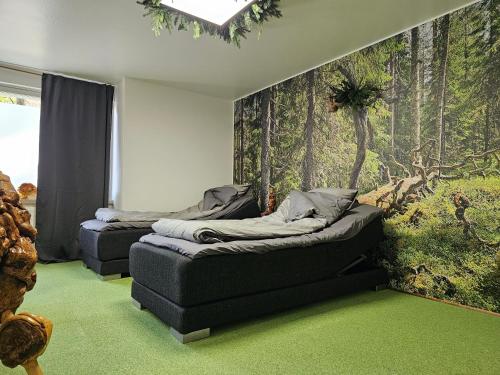 two beds in a room with a mural of a forest at ROVIO REST IN FOREST in Jyväskylä