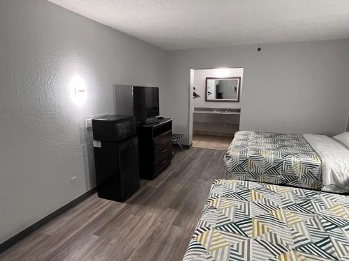 a hotel room with two beds and a television at Motel 6 Oklahoma City OK Fairgrounds West in Oklahoma City