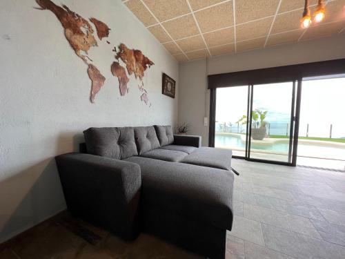 - un salon avec un canapé et une carte du monde sur le mur dans l'établissement Apartament Llevant 8, à Lloret de Mar