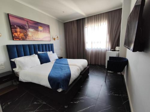 een hotelkamer met een groot bed en een raam bij Spirit of Herzl Hotel in Jeruzalem