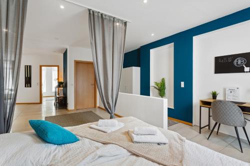 una camera da letto con pareti blu e un letto con cuscini blu di Groß, modern, vollausgestattet, gemütlich mit Küche und Parkplatz für Urlaub oder Business a Kettig