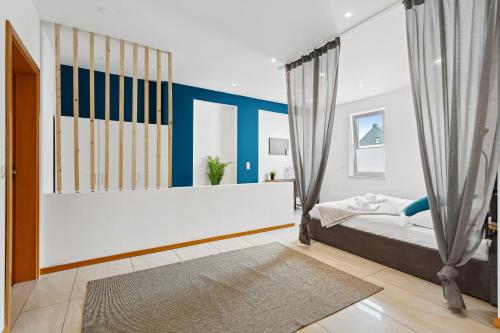una camera da letto con pareti bianche e blu e un letto di Groß, modern, vollausgestattet, gemütlich mit Küche und Parkplatz für Urlaub oder Business a Kettig