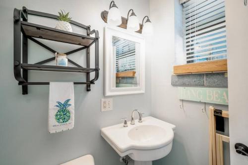 a bathroom with a sink and a toilet and a mirror at Why Knot Getaway…Rooftop with WaterView! Unit F in Beaufort