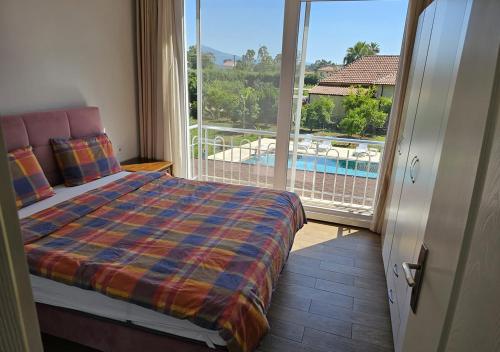 1 dormitorio con 1 cama y balcón con piscina en Marmaris Hisarönü'nde Havuzlu Villa, en Marmaris