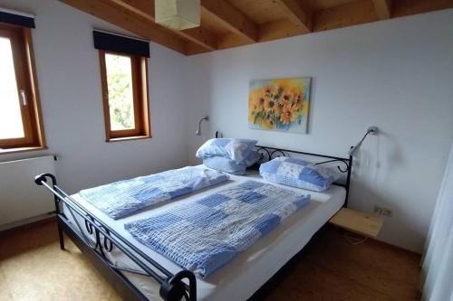 Un dormitorio con una cama en una habitación blanca. en Ferienwohnung Seebaer, en Ramsberg