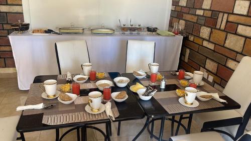 een tafel met borden en kommen met eten erop bij The Mevrose Resort in Kisii