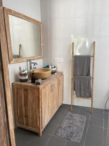 uma casa de banho com um lavatório de madeira e um espelho em Villa Salamanca em Dalung